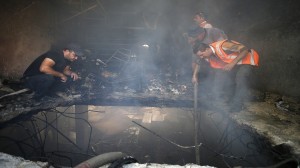 Palestinians inspect the scene where Israeli troops shot dead two Palestinians in the West Bank city of Hebron