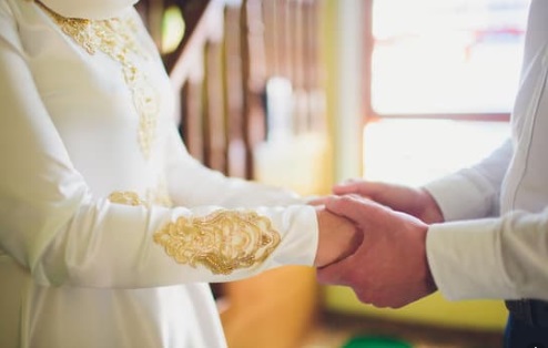 زوج يمسك بيد زوجته ، زفاف - أوراق عربية